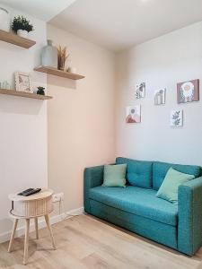 a living room with a blue couch and a table at Studio le Magnolia in Lavaur