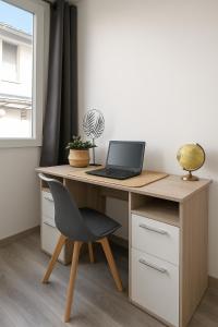 a desk with a laptop computer on top of it at Le Vosgien - Hyper center - Calme - Wifi - Spacieux in Épinal +10 photos