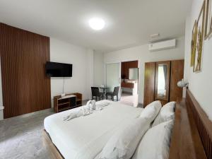 a bedroom with a large white bed and a television at Wilawan home in Ko Samui