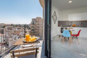 a balcony with a table and chairs and a kitchen at Eshel Suites Even Israel in Jerusalem