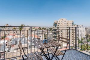 a table and chairs on a balcony with a view of a city at Eshel Suites Even Israel in Jerusalem