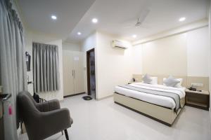 a hotel room with a bed and a chair at Hari Haran Prestige in Varanasi