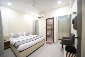 a hotel room with a bed and a chair at Hari Haran Prestige in Varanasi +18 photos