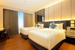 Postel nebo postele na pokoji v ubytování FUGO Hotel Banjarmasin