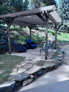 a wooden pergola with chairs on a patio at Peaceful in Evergreen +4 photos