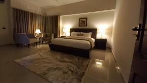 a hotel room with a bed and a couch and chairs at CHK INN by ChenOne in Lahore +10 photos