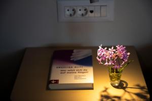 un livre et un vase de fleurs sur une table dans l'établissement Kavo Plako Studio 1, à Palekastro