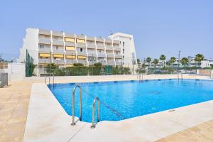 a swimming pool in front of a building at Beachside Bliss in Caleta De Velez