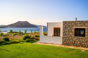 une maison en pierre avec vue sur l'océan dans l'établissement Kavo Plako Studio 1, à Palekastro