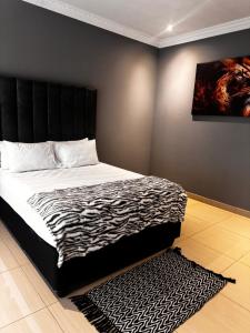 a bed with a black headboard in a bedroom at Lukholo Guest House in Vosburg