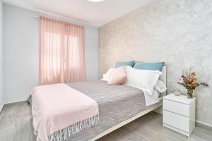 a bedroom with a bed with pillows and a window at Beachside Bliss in Caleta De Velez +16 photos