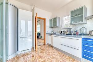 eine Küche mit weißen Schränken und blauen Arbeitsflächen in der Unterkunft Villa Luce del Sol Lux with Pool - L - Happy Rentals in Albenga