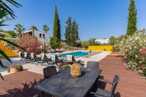 a patio with a table and chairs and a pool at Finca Lavinia in Alhaurín el Grande