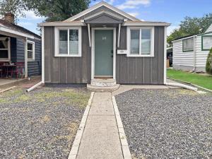 una casa marrone con una porta verde in un vialetto di River City Hideaway cottage a Grand Junction