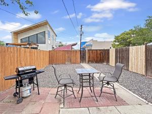 a backyard with a table and chairs and a grill at River City Hideaway cottage in Grand Junction