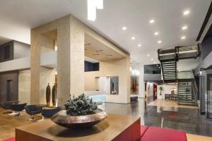 a large living room with a table and chairs at Ramada by Wyndham Oradea in Oradea