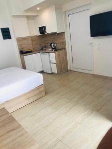 a room with a bed and a kitchen with a door at Navarino Luxe Suites in Perea