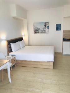 a bedroom with a large white bed in a room at Navarino Luxe Suites in Perea