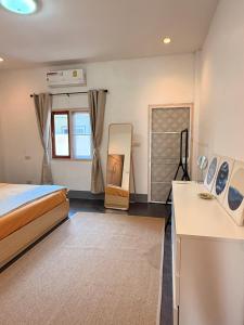 een slaapkamer met een bed en een bureau met een spiegel bij Tropical 1 Bedroom Pool House In Central Location in Hua Hin +9 foto's