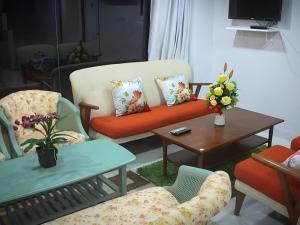 スラート・ターニーにあるChic Hotel Suratthaniのソファと椅子とテーブルのあるリビングルーム