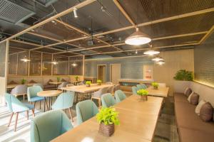 un ristorante con tavoli di legno e sedie blu di TRUE GO Hotel Bejing Sanyuangiao Yansha a Pechino