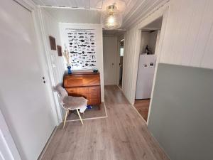 un corridoio con una sedia e un comò in una stanza di 6 person holiday home in KLOKKARVIK a Klokkarvik Altre 30 foto