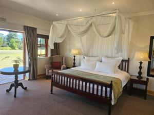 L'Heritage Retreat في Wildernis: غرفة نوم بها سرير كبير وطاولة +11 صورة