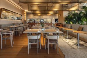 a dining room with tables and chairs in a restaurant at Radisson Blu Hotel Batumi in Batumi