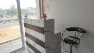 a chair sitting next to a desk with a window at Super Star hotel in Derāpur