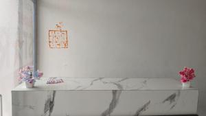 a white marble shelf with flowers on a wall at Super Star hotel in Derāpur