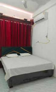 a bed in a room with a red curtain at Super Star hotel in Derāpur