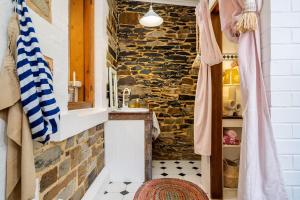 une salle de bain avec un lavabo et un mur en pierre dans l'établissement Coachman's Cottage Glenelg, à Glenelg 14 autres photos