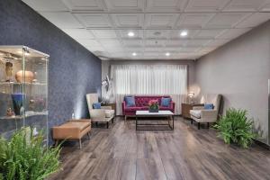 a waiting room with a red couch and chairs at The Penn Stroud, Stroudsburg - Poconos, Ascend Hotel Collection in Stroudsburg