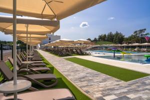 a row of chairs and umbrellas next to a pool at Hotel Ostaniec in Kroczyce
