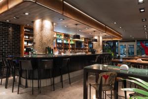 a bar in a restaurant with chairs and tables at Dazzler by Wyndham Montevideo in Montevideo