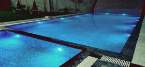 a large swimming pool with blue lights on it at Hotel Surya Inn in Kānsrao +7 photos