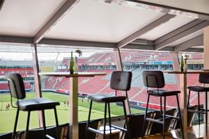 Blick auf ein Baseballstadion von einer Bar mit Hockern aus in der Unterkunft The Curve Hotel BayArena in Leverkusen