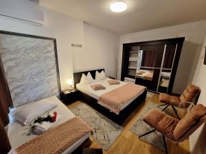 a hotel room with two beds and two chairs at Ana's Garden Sibiu in Sibiu
