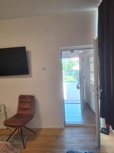 a room with a chair and a sliding glass door at Ana's Garden Sibiu in Sibiu
