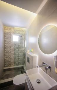 a bathroom with a sink and a toilet and a mirror at Kalipso in Paralia Katerinis