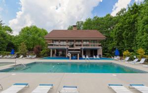 a large swimming pool with chairs and a house at Among The Clouds 2240 in Gatlinburg