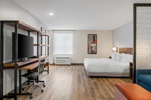 a hotel room with a bed and a desk at Everhome Suites Bozeman in Bozeman +43 photos
