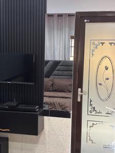 a door to a room with a television and a bedroom at Cityscape Apartment in Trofwi +7 photos