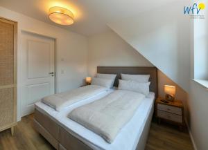 a bedroom with a large bed with white sheets at Haus Casper Ferienwohnung 4 in Langeoog