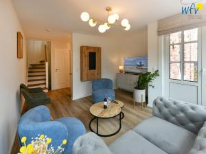 a living room with blue couches and a table at Haus Casper Ferienwohnung 2 in Langeoog