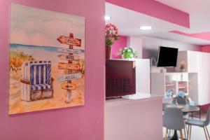 ein Raum mit einem Gemälde eines Stuhls und Straßenschildern in der Unterkunft Estudio Arena, A Pie De Playa in Cádiz