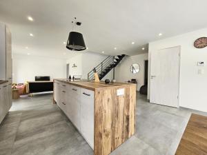 a kitchen with a wooden island in a room at Comme A La Maison in Lucey