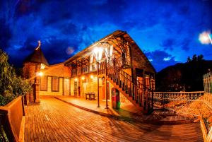 een gebouw met een houten terras met verlichting bij Hosteria de la Plaza Menor in Santa Fe de Antioquia