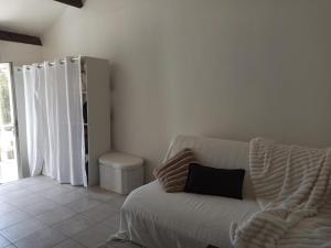 a living room with a white couch with a pillow at Studio cosy in Sorgues