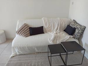 a white couch with two pillows and a table at Studio cosy in Sorgues